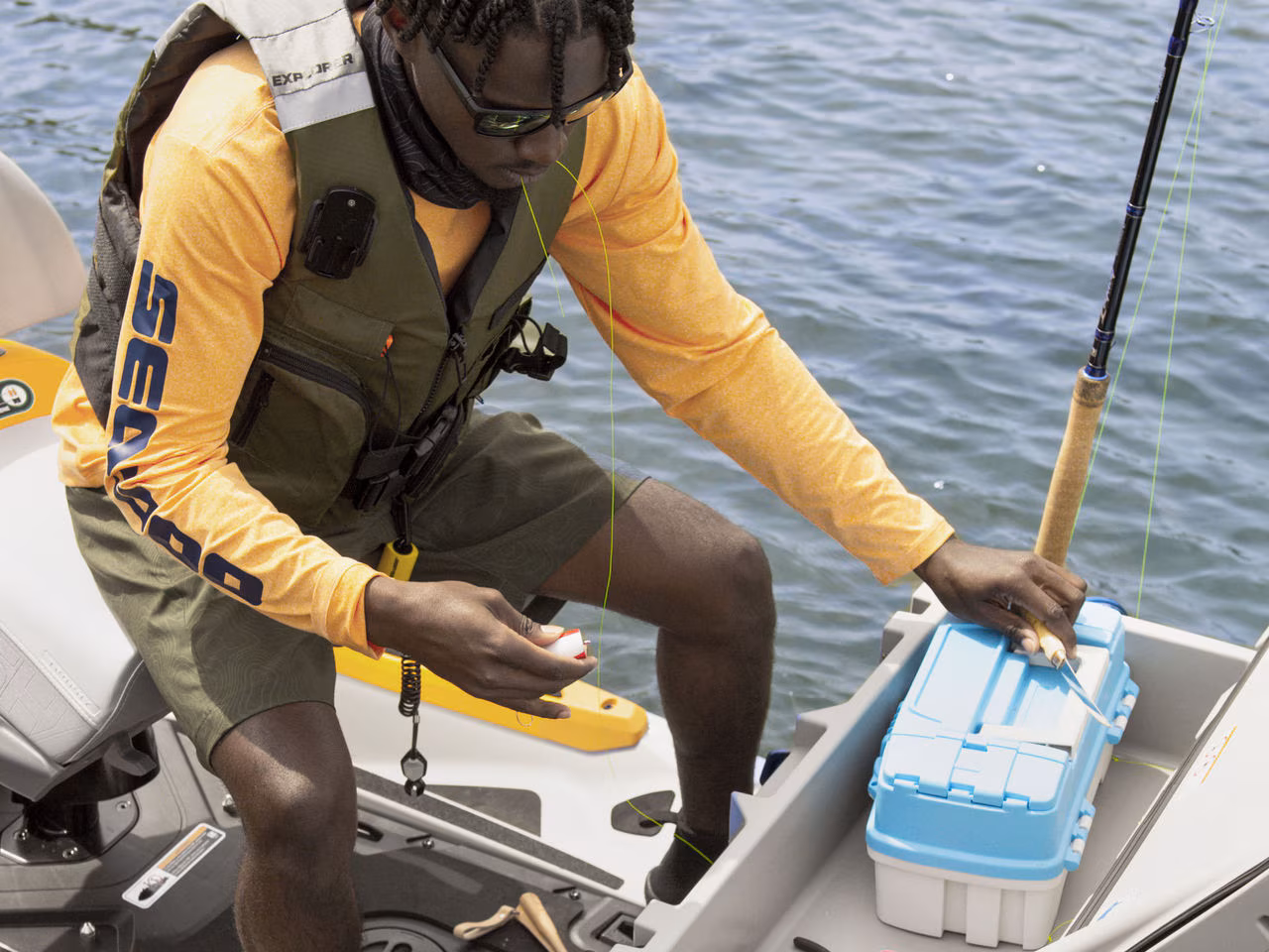 Чоловік з рибальським спорядженням на своєму гідроциклі Sea-Doo